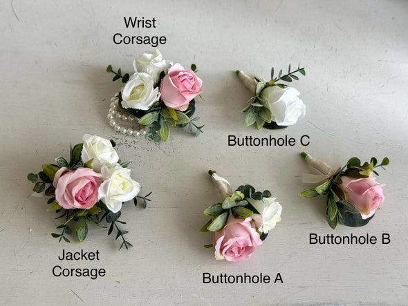 Pale pink and ivory roses silk wedding flowers buttonholes and corsages. Buttonholes are worn by the groom, groomsmen and fathers. Corsages are worn by the mother of the bride and mother of the groom.