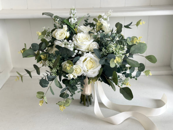 Rustic white and green silk wedding flowers bride bouquet. White roses, gypsophila and eucalyptus.