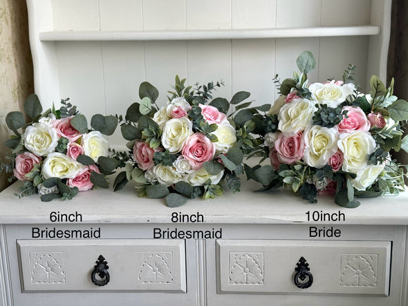 Pale pink and ivory roses silk wedding flowers with eucalyptus and sage greenery. Pink and ivory artificial wedding bouquets for the bride and bridesmaids.