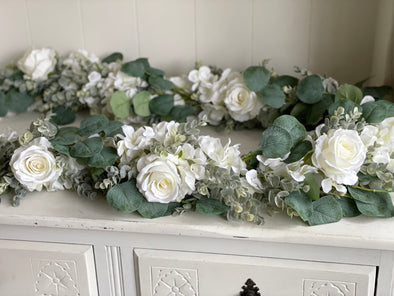White and green artificial garland. Roses, hydrangea and eucalyptus